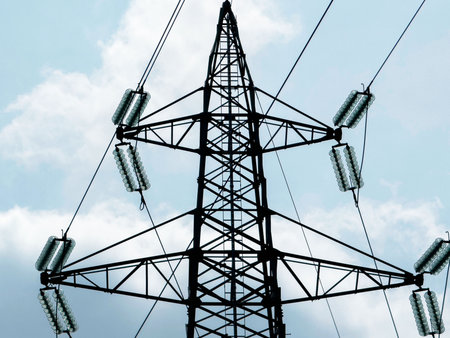 High voltage transmission tower against cloudy sky background.の写真素材