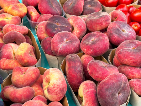 Fresh organic donut peaches in cardboard baskets at farmers market.の写真素材