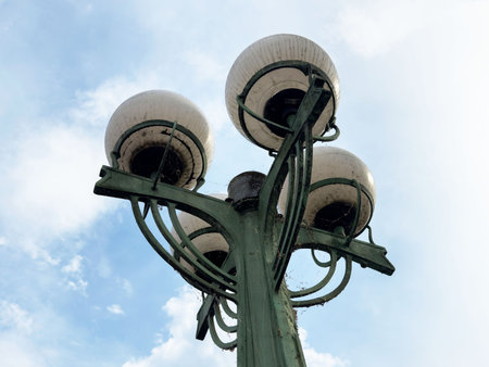 Vintage green street lamp against cloudy sky on sunny day.の写真素材