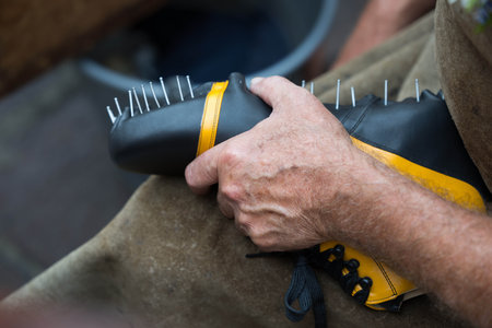 Craftsman assembling spiked shoe with precision and skill.