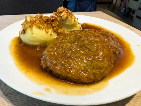 Delicious salisbury steak with mashed potatoes and gravy on white plate.の写真素材