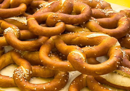 Pile of freshly baked salted pretzels with golden brown crust.