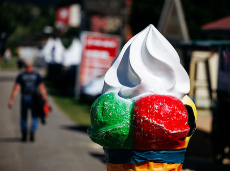 Large ice cream cone sculpture in outdoor setting with blurred background.の写真素材