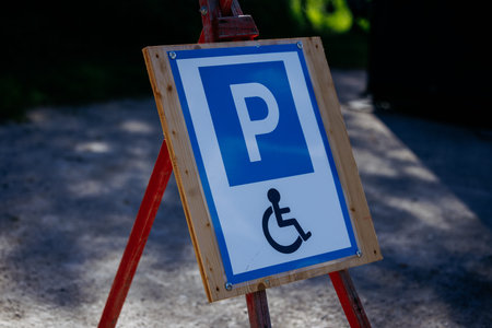 Accessible parking sign on wooden frame in outdoor setting.