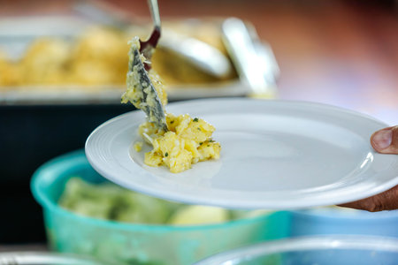 Serving salad on white plate in kitchen setting.