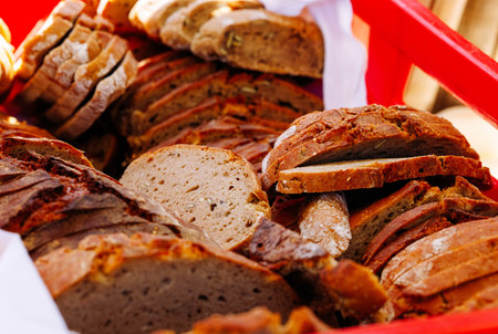 Variety of freshly baked artisan bread displayed in a red basket.