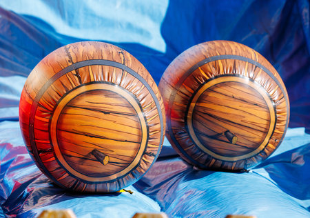 Inflatable barrel-shaped beach balls on blue background.