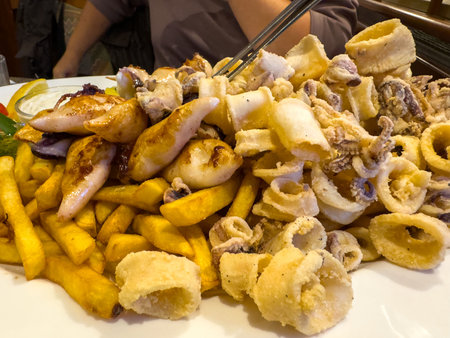 Delicious fried calamari and french fries on plate.の写真素材
