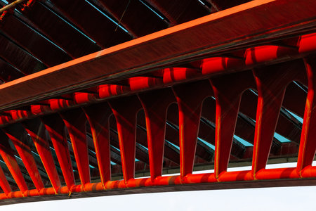 Red architectural bridge with intricate design and structural patterns.の写真素材