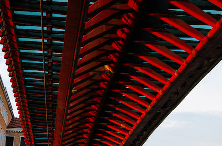 Geometric patterns and reflections in modern red bridge architecture.の写真素材