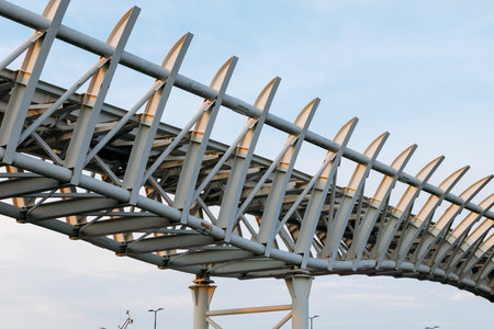 Modern steel bridge structure with geometric design against sky background.の写真素材