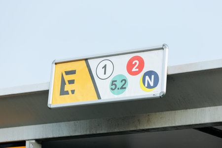 Modern parking garage sign with color-coded numbers and symbols.の写真素材