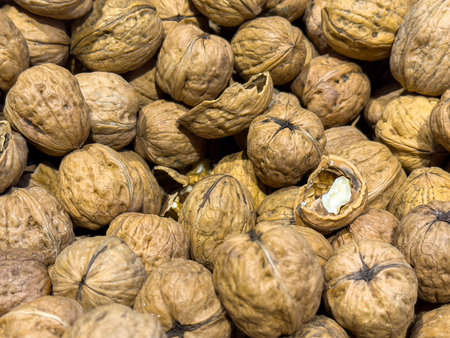 Close-up of whole walnuts with cracked shells displaying nutty texture.の写真素材
