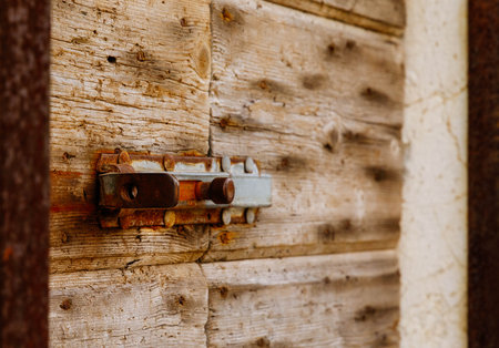 Rustic wooden door with vintage metal latch showing weathered texture.の写真素材