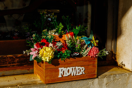 Rustic flower box with colorful bouquet on sunlit window ledge.の写真素材