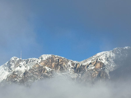 Snow-covered mountain peaks with blue sky and clouds.の写真素材