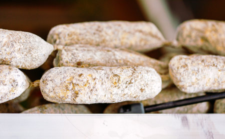 Close-up of dry cured sausages in artisan market display.