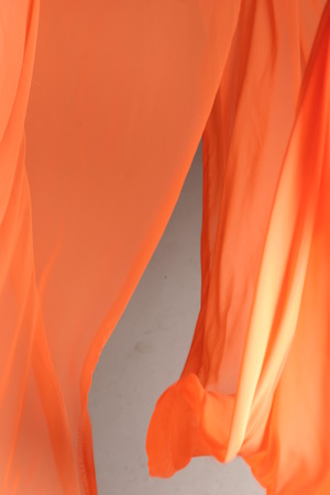 Soft orange chiffon with curve and wave isolated on the grey background.の写真素材