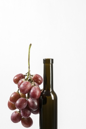 Red Grapes and wine bottle isolated on white backgroundの写真素材