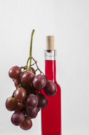 Red Grapes and wine bottle isolated on white backgroundの写真素材