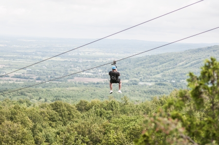 Man zip lining over the tree canopyの写真素材