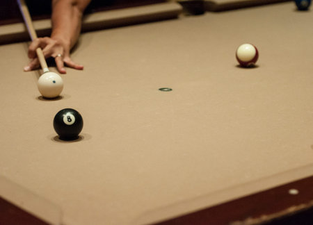 player aiming for the shot by a White cue ball and 8 ball