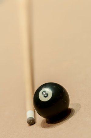 8 ball and a cue stick on billiard table