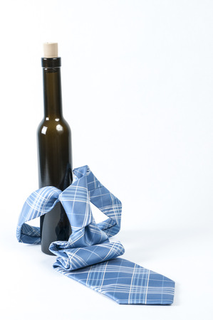 Neck tie over a wine botttle on white back groundの写真素材