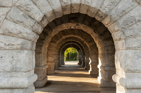 A series of stone arches with sun shining throughの写真素材