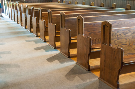A row of antique  wooden church pews.のeditorial素材