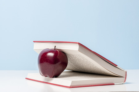 An apple wedge between pages of an open bookの写真素材