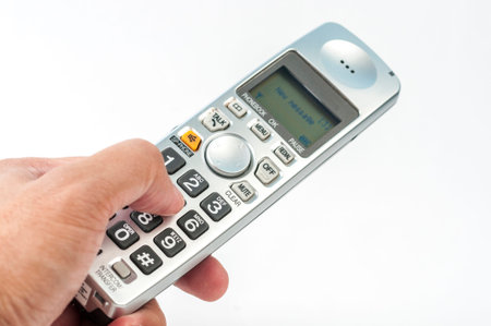 Hand dialing a digital phone on white back ground.