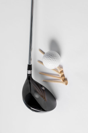Golf essentials, club, ball and tee on white background