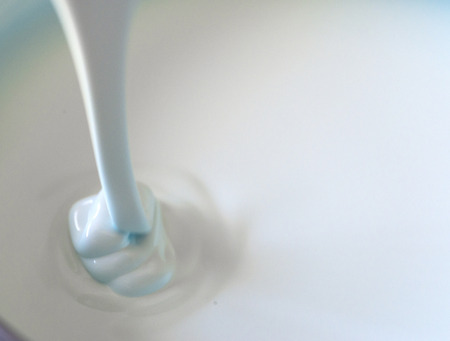 Close up of a flowing milk shake with tint of blue.の写真素材