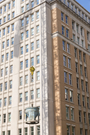 Cable lifting a concrete bucket with building in the back groundの写真素材