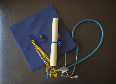 Graduation hat, stethoscope and rolled diplomaの写真素材