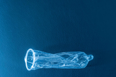 Prophylactic condom on a bkuish textured back ground