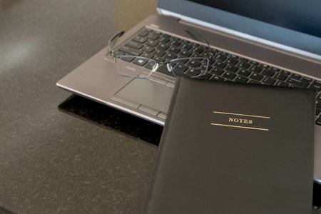 Laptop note book and glases in a home office set up