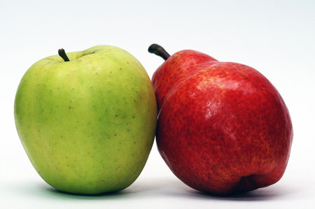 Green apple and red pear on whiteの写真素材
