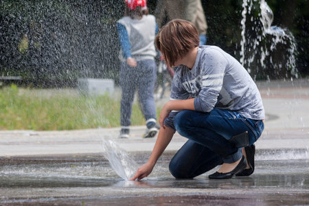 Bialystok , Poland , June 12, 2016: Fountain  a young girl playing with water