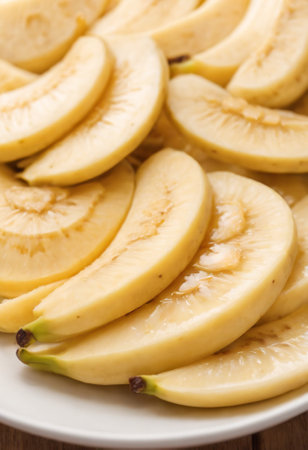 Slices of fresh yellow bananas on a plate close-upの素材