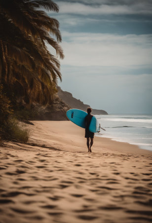 Surfer with his surfboard on the beach on a cloudy dayの素材