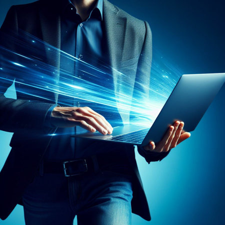 Close up of businessman holding laptop with glowing lines on dark blue backgroundの素材