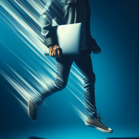 Young man with a laptop in his hands on a blue background.の素材