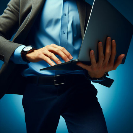 Businessman working with laptop on blue background. Close-up.の素材