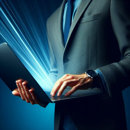 Close up of businessman using laptop with light beam coming out of the screenの素材