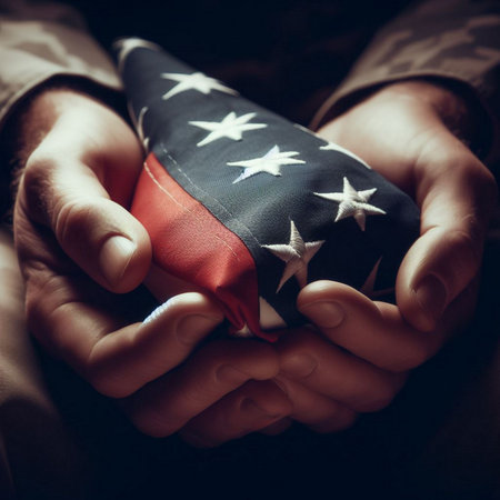Hands of a man holding an American flag on a dark backgroundの素材