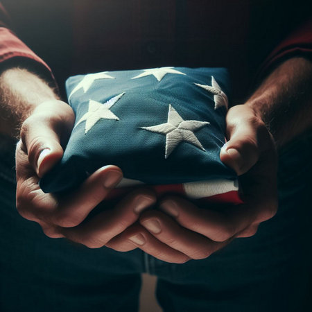 A close-up shot of a hand holding a folded American flagの素材