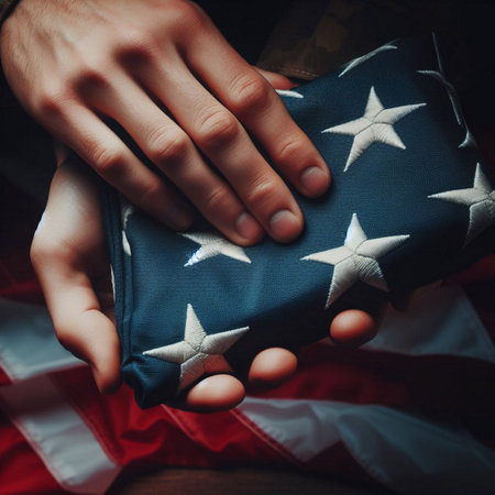 A close-up shot of a hand holding a folded American flagの素材