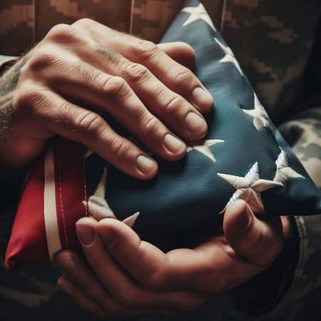 A close-up shot of a hand holding a folded American flagの素材